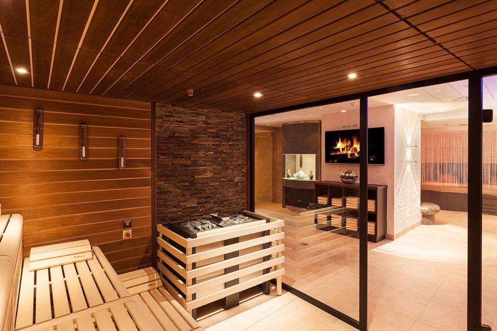SPA Betreiber 8 Wellnessbereich mit Sauna im Sauerland Stern Hotel: Bio Sauna mit Glasfront und großem Saunaofen für kräftige Aufgüsse. made by corso sauna manufaktur