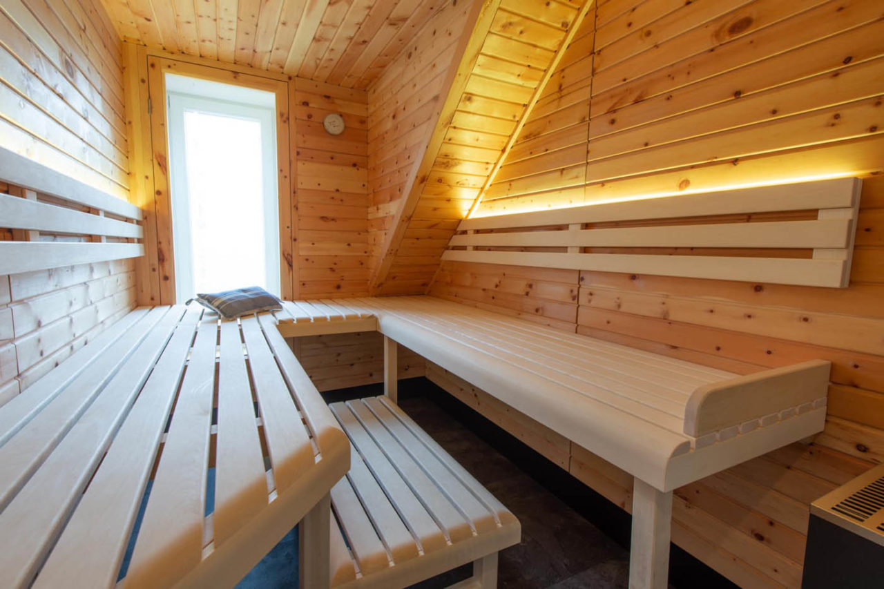 Sauna Ideen für Zuhause | 20 Top Projekte 17 Zirbenholz Sauna unter der Dachschräge in Maßanfertigung mit eingearbeitetem Fenster und Glasfront
