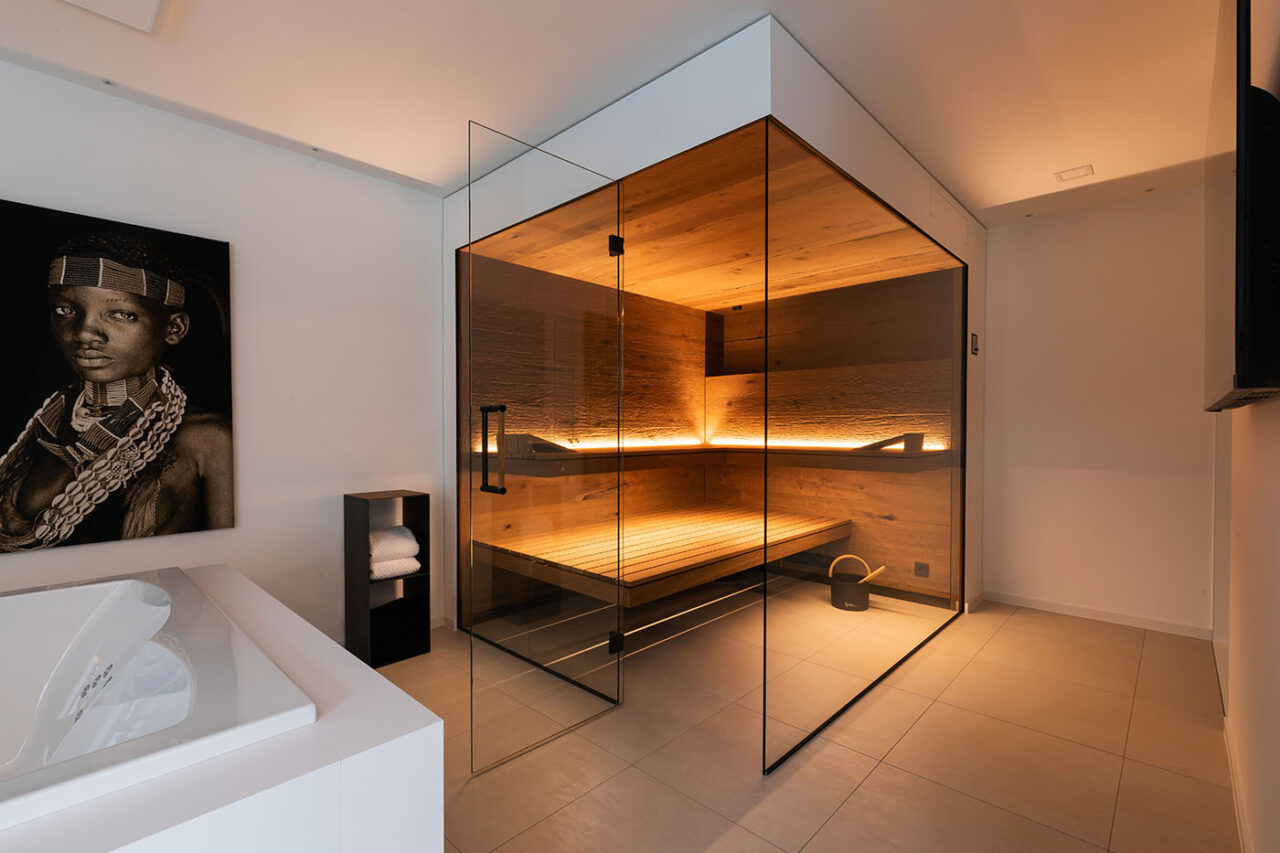 Moderne Sauna mit Glasfront 6 Ecksauna in Eiche und Thermo-Espe mit zweiseitiger Verglasung, schwebenden Bänken, Hinterwandofen und verdeckt eingebautem Infrarot Strahler