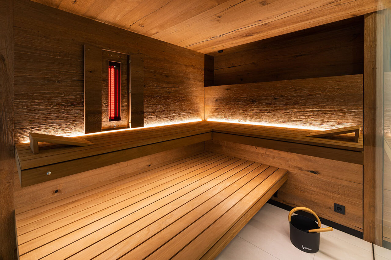 INFRAROTSAUNA 8 Premium Ecksauna in Eiche und Thermo-Espe mit zweiseitiger Verglasung, schwebenden Bänken, Hinterwandofen und verdeckt eingebautem Infrarotstrahler. Kombi aus Sauna und Infrarotkabine.