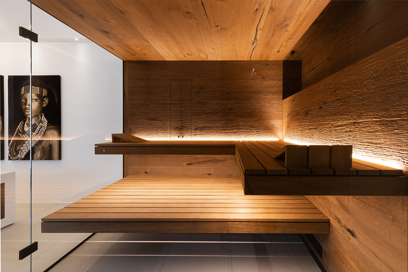 Saunaholz | Holzarten 11 Ecksauna in Eiche und Thermo-Espe mit zweiseitiger Verglasung, schwebenden Bänken, Hinterwandofen und verdeckt eingebautem Infrarot Strahler