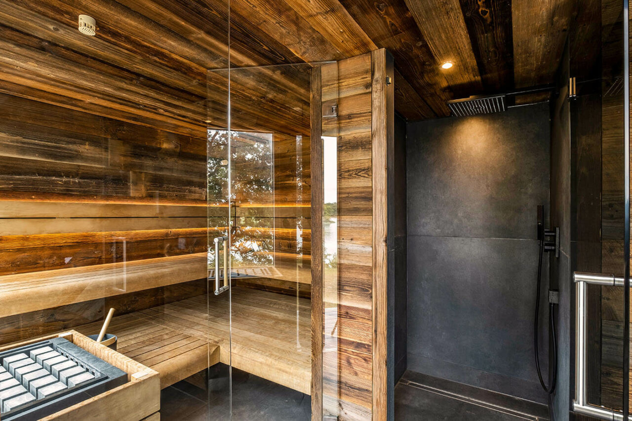Außensauna Hotel: Gartensauna im Außenbereich direkt am See beim Hotel Lichtenberg mit Ruheraum und Dusche. Innengestaltung in Altholz, Außengestaltung passend zum Hotel.