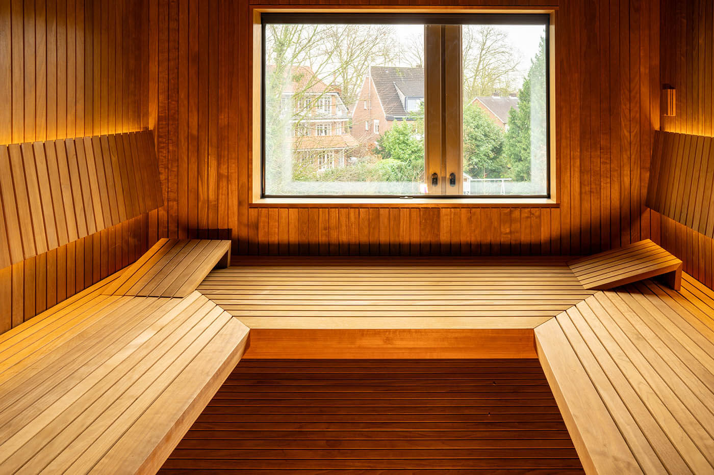 Sauna avec coin en verre à l’aspect baguettes 15 Sauna design sur mesure avec coin en verre à l’aspect thermo-tremble avec éclairage indirect LED du dossier et fenêtre extérieure. Sauna bio. Saunabau Münster.