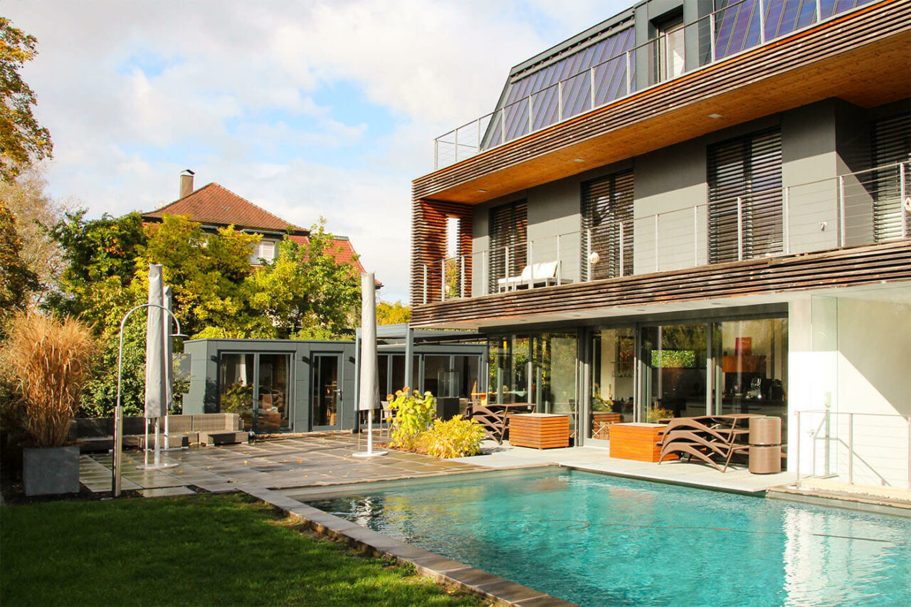 Pool house sur mesure avec façade vitrée 204 Poolhaus nach Maß mit zu öffnender Glasfront, Daybed, Kaffeeküche und Lounge. Außenverkleidung in wetterfesten Trespa Schichtstoffplatten.
