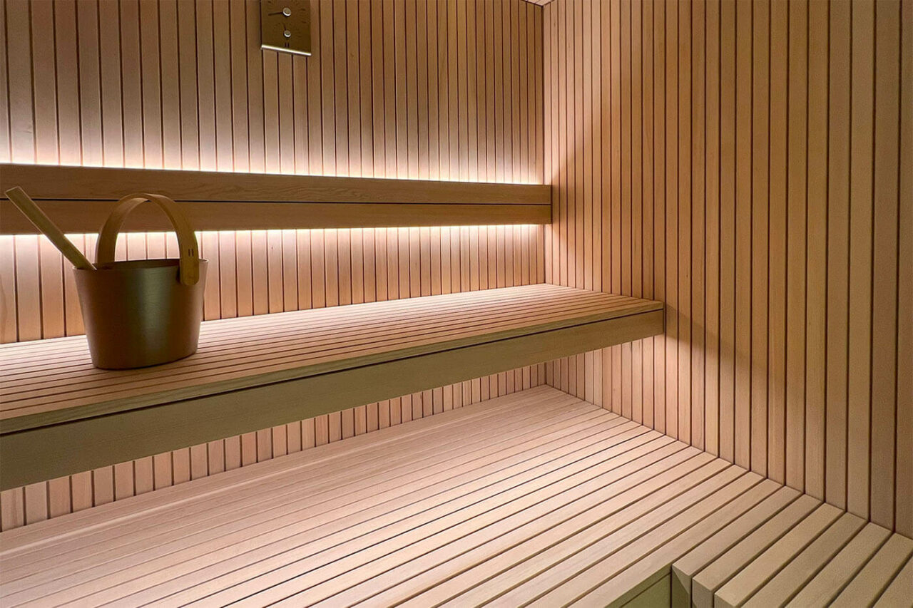 Hemlock Sauna Stäbchenoptik 62 Hemlock Sauna in Stäbchenoptik als Maßanfertigung mit großer Glasfront und nach außen verlängerter Bank. Direkt vom Saunabauer.
